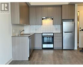 A kitchen with a stove top oven and a refrigerator.