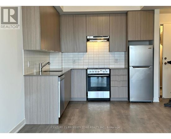 A kitchen with a stove top oven and a refrigerator.