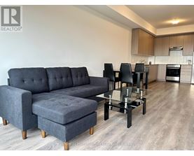 A grey sofa and ottoman in a modern living room.