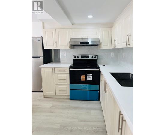 A kitchen with a black stove top oven and a blue dishwasher.
