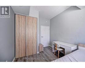 A bedroom with a bed, desk, and wardrobe.