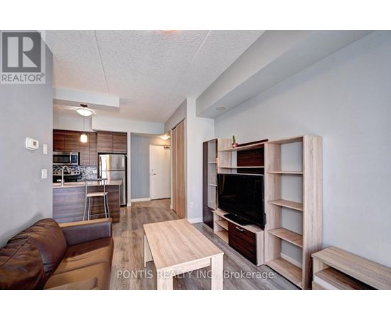 A living room with a brown leather couch and a wooden entertainment center.