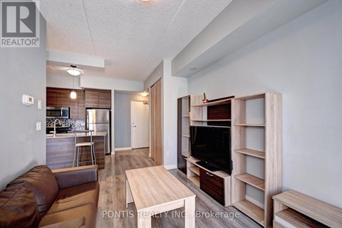 A living room with a brown leather couch and a wooden entertainment center.