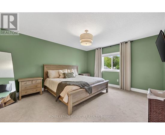 A bedroom with a bed, nightstand, and window.