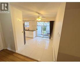 A spacious room with a sliding glass door leading to a balcony.