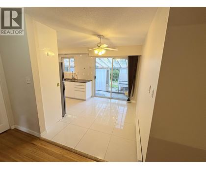 A spacious room with a sliding glass door leading to a balcony.