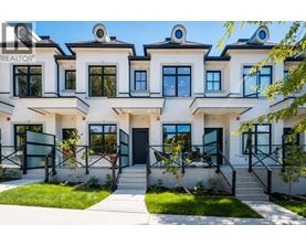 A white building with black railings and windows is labeled REALTOR.