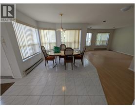 A dining room with a table and chairs.