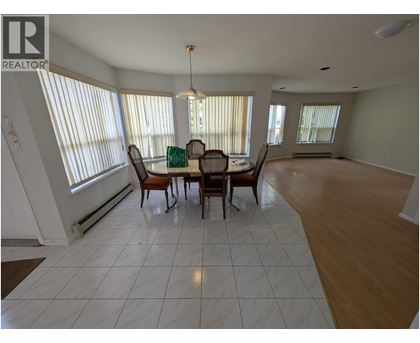 A dining room with a table and chairs.
