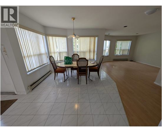 A dining room with a table and chairs.