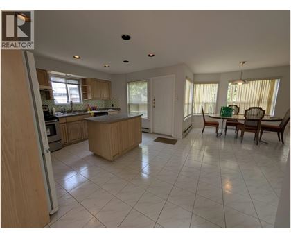 A spacious kitchen with a dining table and chairs.
