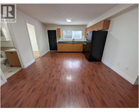 A large empty room with wooden floors and white walls.