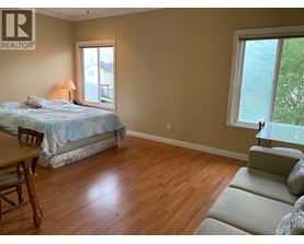 A bedroom with a bed, chair, and window.