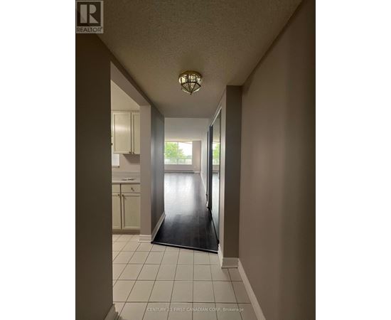 A hallway with a light on and a door at the end.