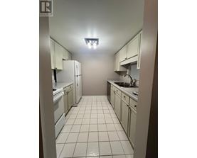 A kitchen with white cabinets and appliances.