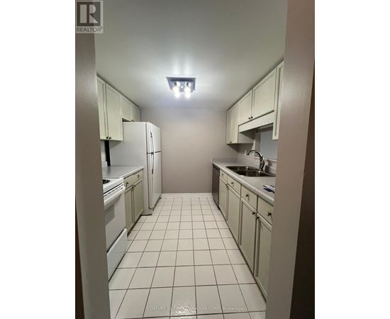 A kitchen with white cabinets and appliances.