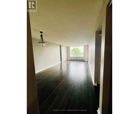 A long hallway with wood floors and a light on the ceiling.