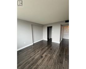 A room with wooden flooring and white walls.