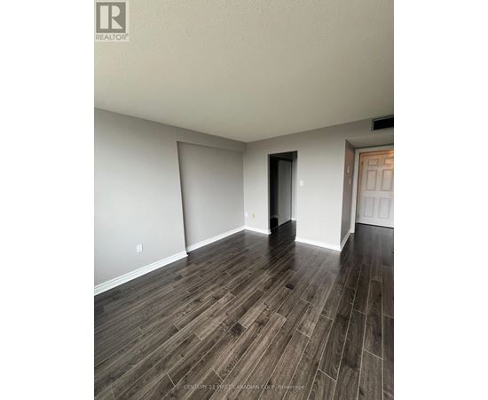 A room with wooden flooring and white walls.