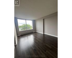 A room with wooden flooring and a large window.
