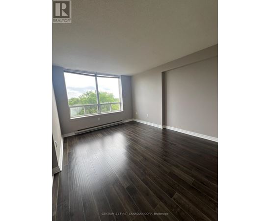 A room with wooden flooring and a large window.