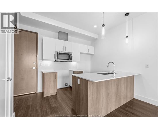 A kitchen with a microwave above the stove and a sink on the counter.