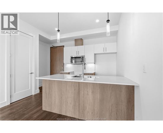A modern kitchen with a white countertop and wooden cabinets.