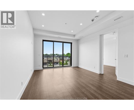 A spacious room with a view of a balcony with a railing.