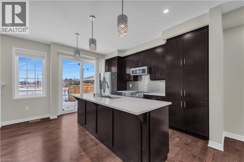 A modern kitchen with dark brown cabinets and a white countertop.