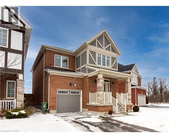 A house with a garage and a driveway in front of it.