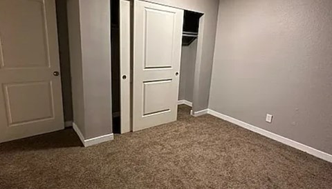A hallway with two doors and a carpeted floor.