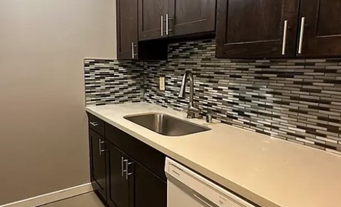 A kitchen with a sink and a backsplash.