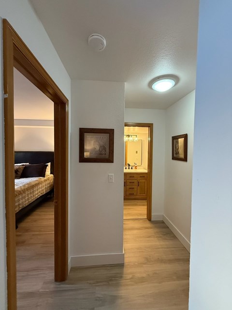 A hallway with a bedroom at the end.