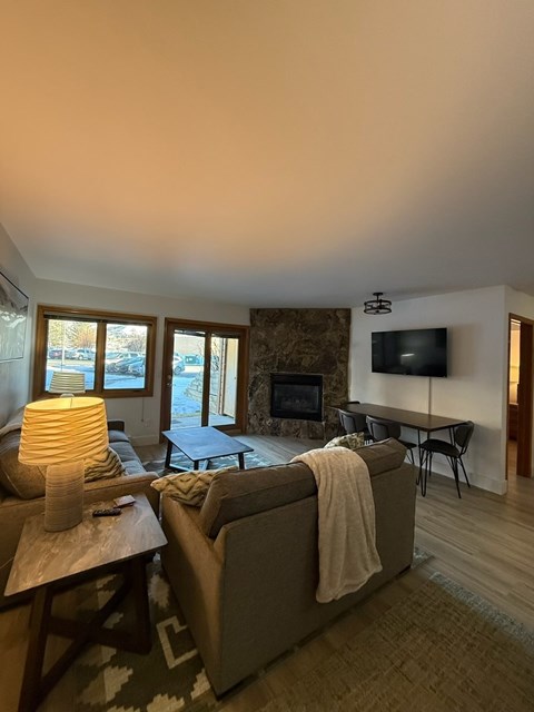 A cozy living room with a fireplace and a television.