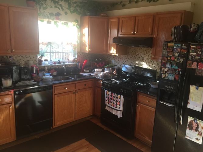 A kitchen with wooden cabinets and black appliances.