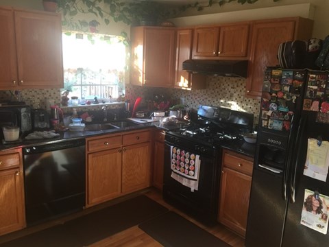 A kitchen with wooden cabinets and black appliances.