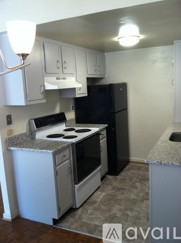 A kitchen with black appliances and white cabinets.