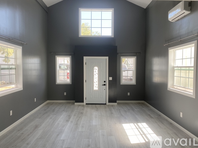 A room with a white door and grey walls.
