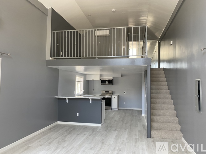 A modern kitchen with a staircase leading to the upper level.