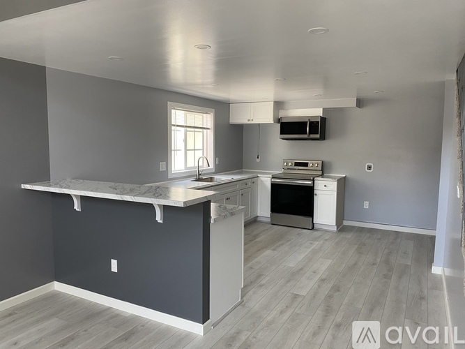 A kitchen with a marble countertop and a window.