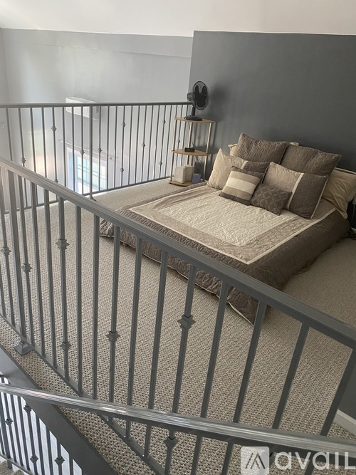 A bedroom with a bed and a metal railing.