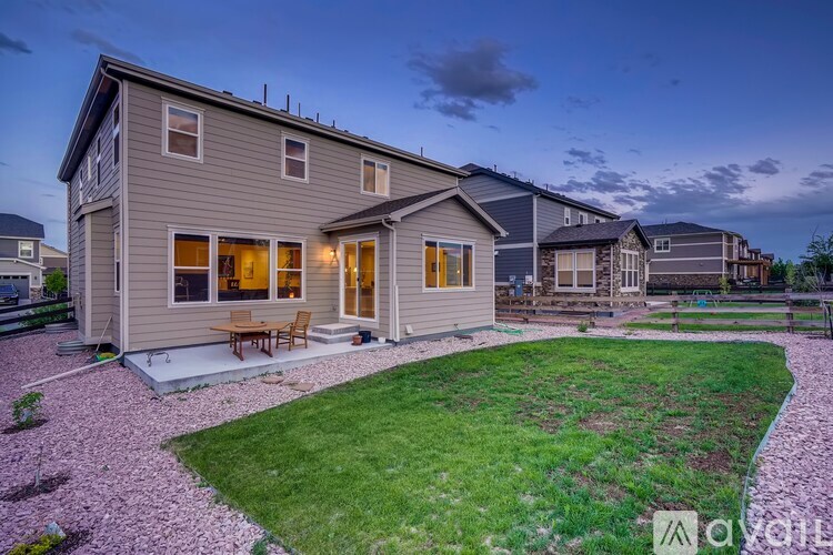 A house with a grey exterior and a patio with a table and chairs.
