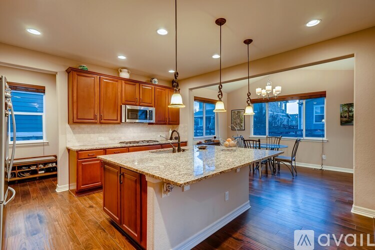 A kitchen with wooden cabinets and a granite countertop.