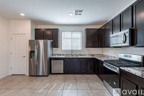 A kitchen with black cabinets and stainless steel appliances.