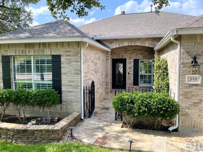 A house with a black door and windows with green shutters.