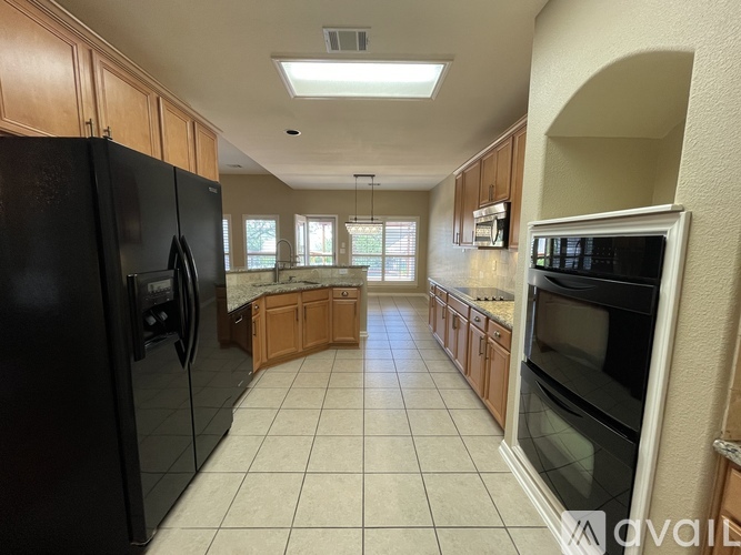 A kitchen with black appliances and wooden cabinets.