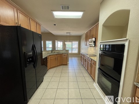 A kitchen with black appliances and wooden cabinets.