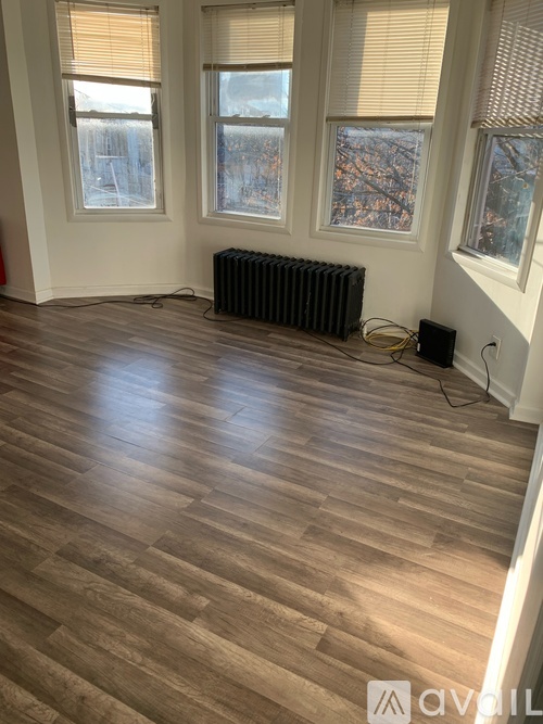 A room with wooden flooring and a radiator.