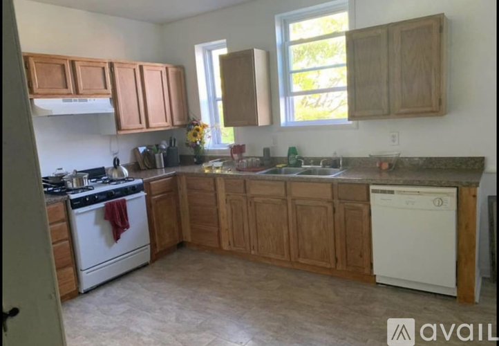 A kitchen with wooden cabinets and a white dishwasher.