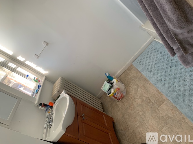 A bathroom with a towel hanging on the shower curtain rod.